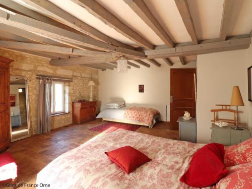 a bedroom with a large bed with red pillows at Maison de charme avec cheminée au cœur du Parc Naturel du Perche - FR-1-497-235 in Loisail