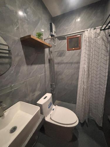 a bathroom with a white toilet and a sink at Villa Serene Resort in General Trias