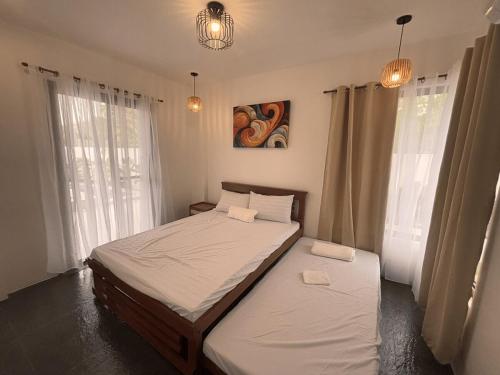 une chambre avec deux lits et deux fenêtres dans l'établissement Villa Serene Resort, à General Trias
