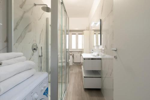 a white bathroom with a sink and a shower at Garbatella Appartamento Moderno Relax e Comfort in Rome
