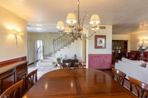 a dining room and living room with a chandelier at Villa Il Castellaccio in Rimini