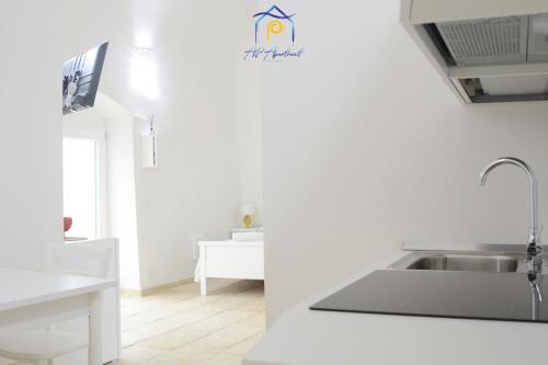 a white kitchen with a sink and a counter at Scaglione Palace in Gallipoli