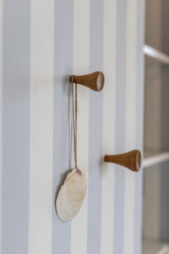 a wooden spoon hanging on a wall with a shelf at Kellers Badehotel in Fanø