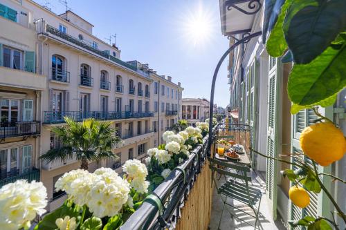 - un balcon orné de fleurs blanches dans un bâtiment dans l'établissement NEW! Remodeled & Spacious 4 Bedroom - 3 Bath - Heart of Nice - AC in all rooms - With a large elevator, à Nice