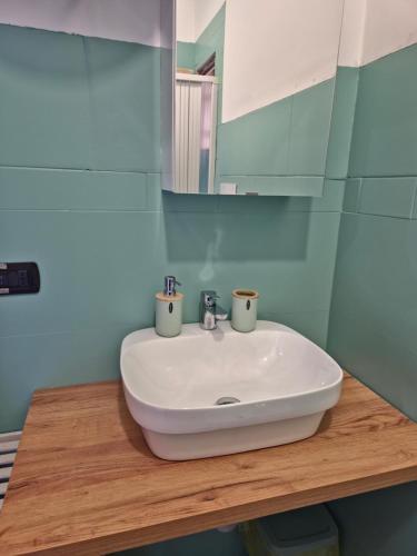 a bathroom sink with two cups on top of it at House del Levante Locazione turistica in Bari