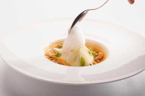 a bowl of soup with a spoon in it at La Meridiana ReIais & Chateaux in Garlenda