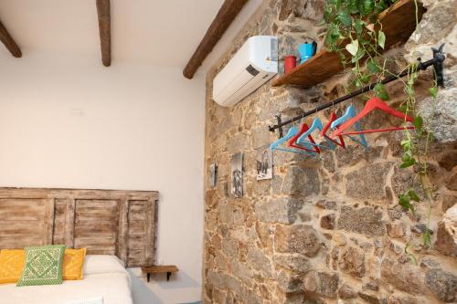 a room with a stone wall and a bed at B&B su Ponte in Orgosolo