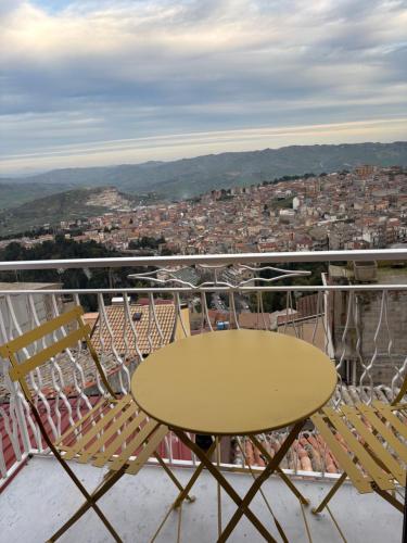 a table and chairs on a balcony overlooking a city at Casa Calogera - Romantica Dimora a Cammarata in Cammarata