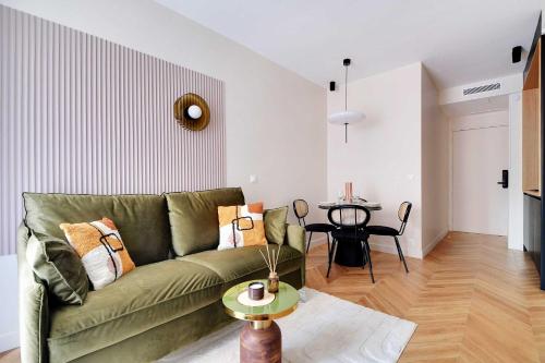 un salon avec un canapé vert et une table dans l'établissement Whole house near the Eiffel Tower, à Paris