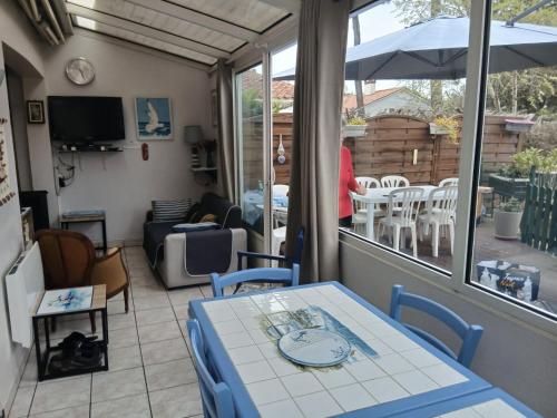 une chambre avec une table, des chaises et un parasol dans l'établissement Sam Su Fi maison de bord de mer, à La Barre-de-Monts