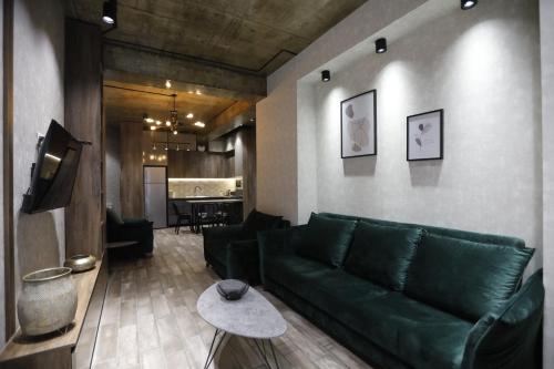 un salon avec un canapé vert et une table dans l'établissement Cozy apartment for travelling, à Tbilissi