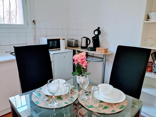 une table en verre avec un vase recouvert d'une fleur dans l'établissement Studio privé - terrasse, parking, WIFI, à Aix-en-Provence