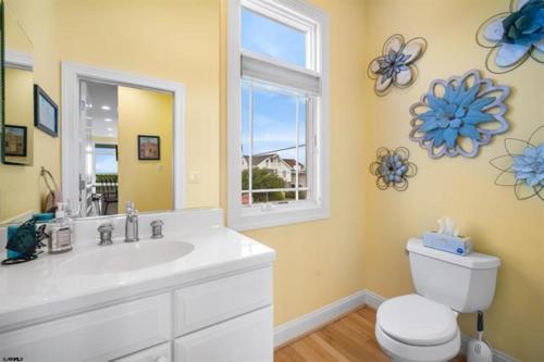 a bathroom with a sink and a toilet and a window at Direct Ocean Front Townhouse! An oceanside gem perfect for any vacation! in Brigantine