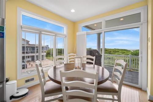 a dining room with a table and chairs and a balcony at Direct Ocean Front Townhouse! An oceanside gem perfect for any vacation! in Brigantine