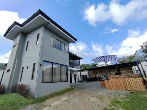 a large white house with a fence in front of it at Casa con Piscina y jacuzzi, vista al Volcán Tenorio in Martirio