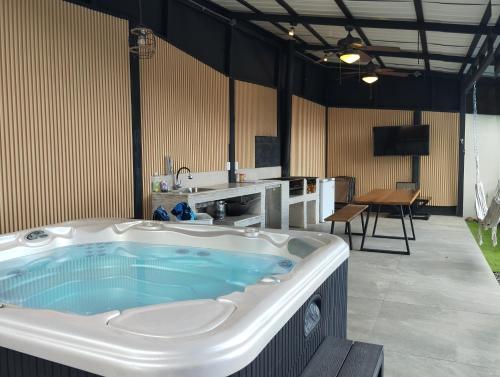 a large bath tub in a room with a table at Casa con Piscina y jacuzzi, vista al Volcán Tenorio in Martirio