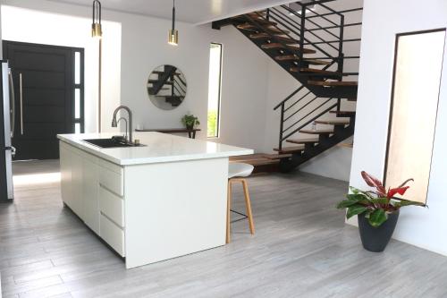 a kitchen with a white counter and a staircase at Casa con Piscina y jacuzzi, vista al Volcán Tenorio in Martirio