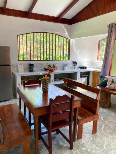 a large kitchen with a wooden table and chairs at Corcovado & Drake Inn in Drake