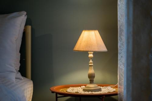 a lamp sitting on a table next to a bed at ToVouno in Plaka