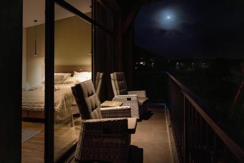 a balcony with a bed and chairs on a balcony at Luxury House Veles in Hisarya