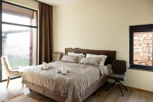 a bedroom with a bed with a chair and a window at Luxury House Veles in Hisarya