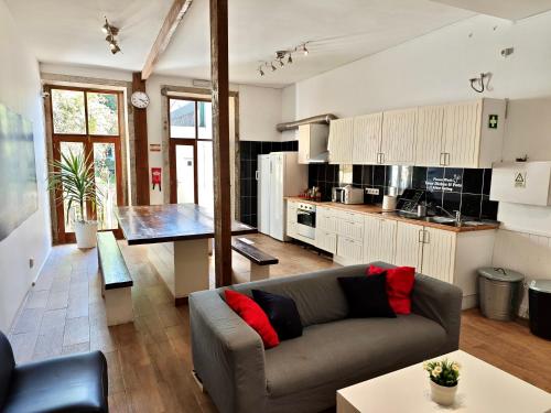 a living room with a couch and a kitchen at GuestHouse Bragas Porto Center in Porto