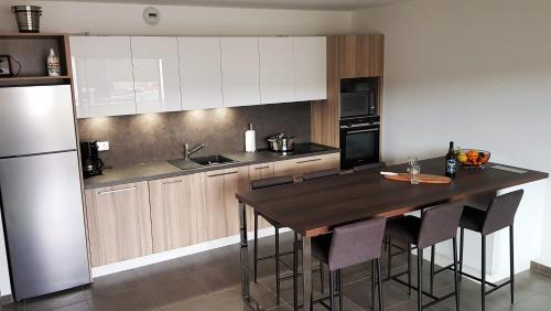 une cuisine avec une table en bois et un réfrigérateur dans l'établissement PORTICCIO Appart 6pers Climatisé proche plage, à Porticcio
