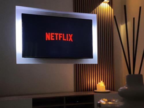 a television with a netflix sign on a wall at Appartement 5 Lits, tout équipé, WiFi, NetfliX in Vaulx-en-Velin