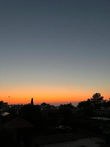 a view of a sunset from the roof of a building at Cheerful and cozy Bungalow with pool and fireplace in Athalassa