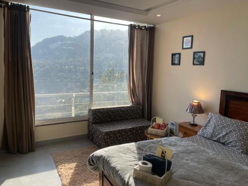 マリーにあるElegant Retreat 206 Studio Apartment with Balconyのベッドルーム1室(ベッド1台、椅子、大きな窓付)