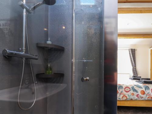 a shower in a bathroom with a glass door at Shay Bank Cottage in Keighley