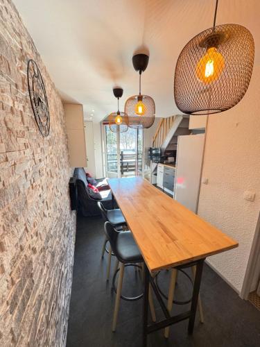 une salle à manger avec une table et des chaises en bois dans l'établissement L'Altitude Douce - Ski - Piscine - Tennis, à Gresse-en-Vercors
