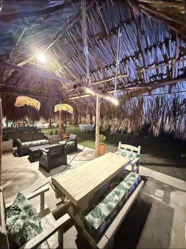 a pavilion with a picnic table and a straw roof at Cabaña Las Tres Palmas in San Bernardo del Viento in San Bernardo del Viento