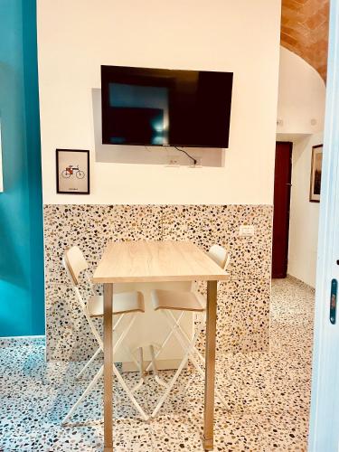 a dining room with a table and a tv on a wall at Rome to You- Easy way Apartment in Rome