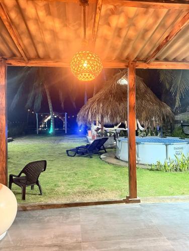 a pavilion with a table and a chair and a chandelier at Cabaña Las Tres Palmas in San Bernardo del Viento in San Bernardo del Viento