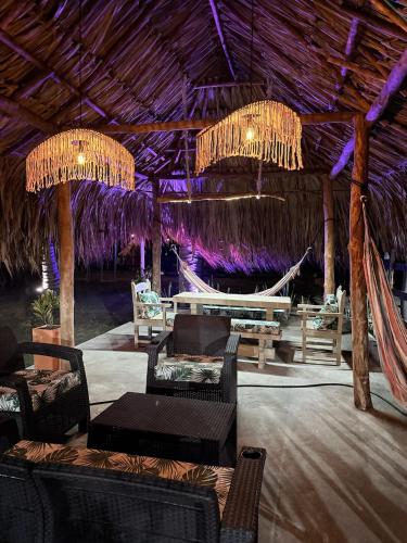 a resort with a hammock and tables and chairs at Cabaña Las Tres Palmas in San Bernardo del Viento in San Bernardo del Viento