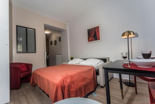 une chambre d'hôtel avec un lit et une table avec une chaise dans l'établissement Saint Michel Quartier Latin With AC, à Paris