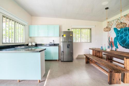 a kitchen with blue cabinets and a stainless steel refrigerator at Cabaña Las Tres Palmas in San Bernardo del Viento in San Bernardo del Viento