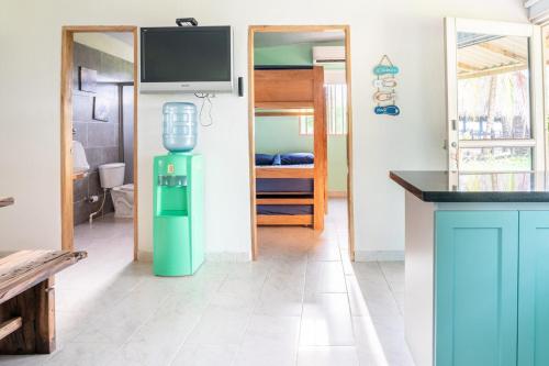 a kitchen with a green water cooler in a room at Cabaña Las Tres Palmas in San Bernardo del Viento in San Bernardo del Viento