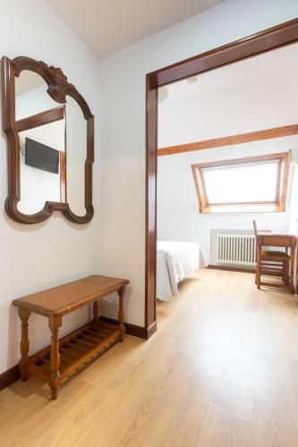 a room with a wooden table and a mirror at Hotel Cabeza in Noreña