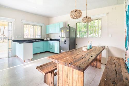a kitchen with a wooden table and blue cabinets at Cabaña Las Tres Palmas in San Bernardo del Viento in San Bernardo del Viento