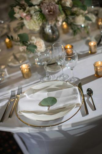 a table with a white plate with a green leaf on it at Renaissance Des Moines Savery Hotel in Des Moines