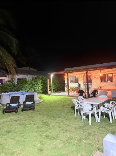 a group of tables and chairs in a yard at night at Cabaña Las Tres Palmas in San Bernardo del Viento in San Bernardo del Viento