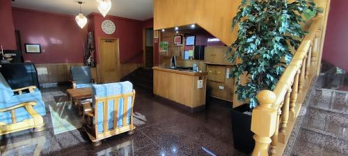 a room with a staircase and a desk with a plant at Hotel A Marisqueira I Aeropuerto A Coruña in Oleiros
