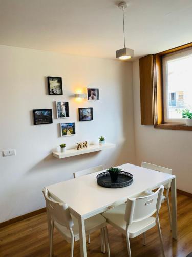 a white dining room with a white table and chairs at Urban Lodge in Braga