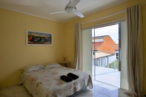 a bedroom with a bed and a sliding glass door at Casa em Iguaba Grande - RJ (Região dos Lagos) (2) in Iguaba Grande