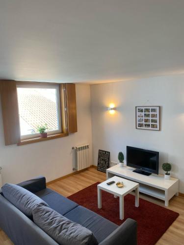 a living room with a couch and a tv at Urban Lodge in Braga