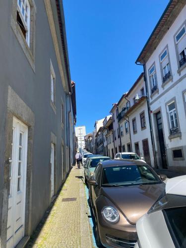 a row of cars parked on a street with buildings at Urban Lodge in Braga