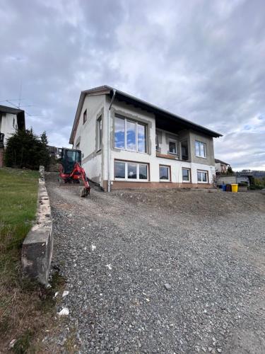 a house with a tractor parked in front of it at Ferienwohnung Schlossblick in Bad Laasphe