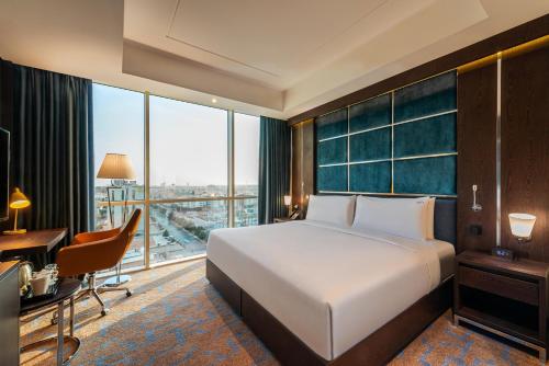 a hotel room with a bed and a desk and a window at Holiday Inn Riyadh AI Malaz by IHG in Riyadh